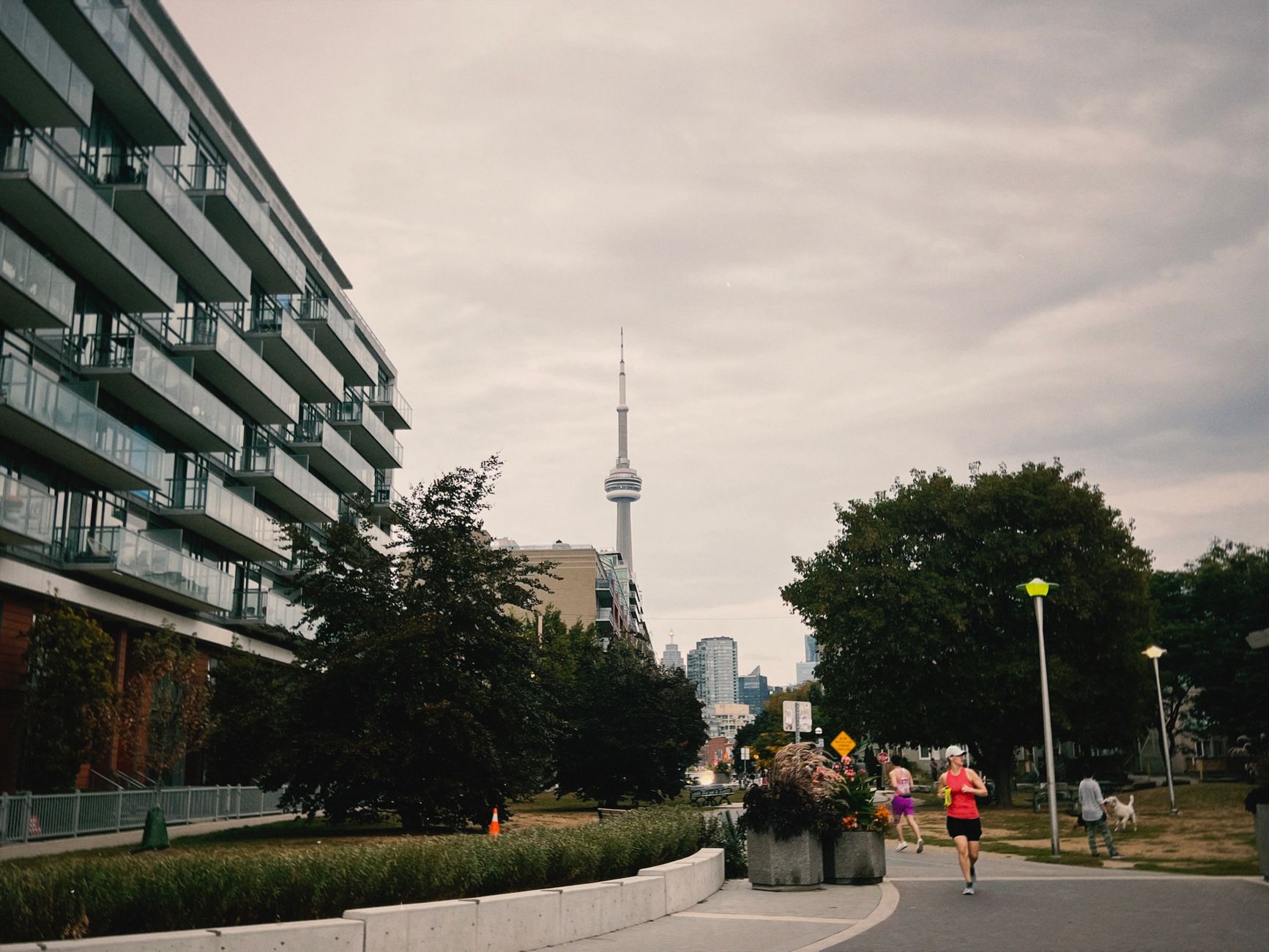 a person running on a sidewalk near a tall building